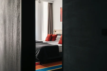 Wygodne łóżko i zaciemniające zasłony w pokoju hotelowym